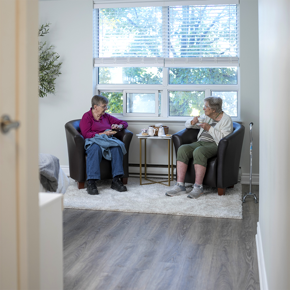 Residents enjoying tea and conversation in a bright, comfortable suite at Atrium Retirement Residence